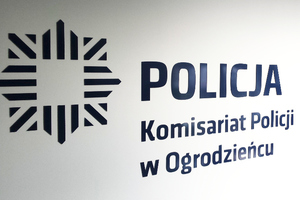 Na białym tle niebieskie logo policji z napisem Komisariat Policji w Ogrodzieńcu.