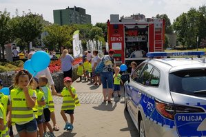 Wóz strażacki, radiowóz i dzieci z opiekunami