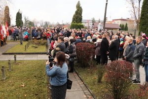 Osoby zgromadzone na cmentarzu przed Pomnikiem Niepodległości.