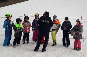 Policjantka podczas prowadzenia pogadanki na temat bezpiecznych wraz z dziećmi u podnóża stoku w Cisowej.
