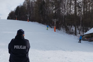 Na zdjęciu widoczny policjant obserwujący stok narciarski.