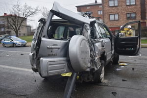 Na zdjęciu widoczne miejsce zdarzenia drogowego. Roztrzaskany samochód, który brał udział w zdarzeniu. W tle radiowóz.